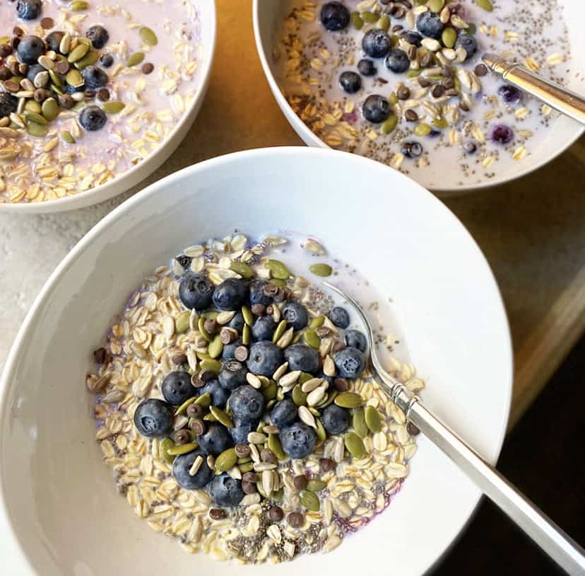 3 bowls of raw oatmeal with fresh fruit