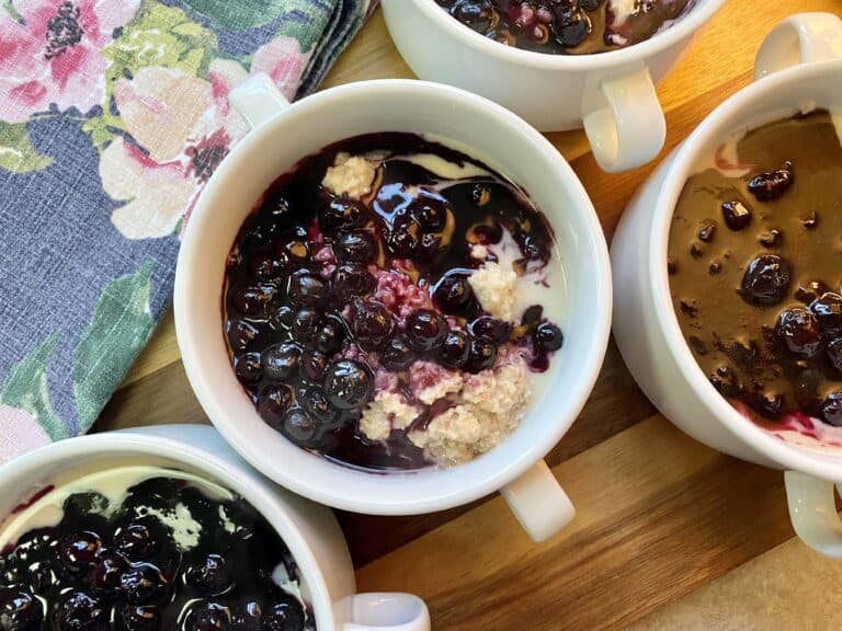 white bowls filled with cream of wheat and blueberry slurry
