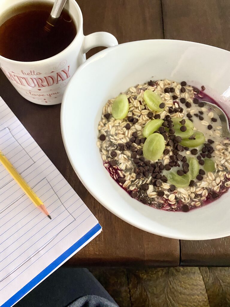 bowl of raw oatmeal topped with grapes