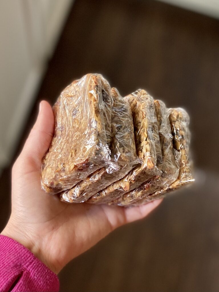 holding breakfast bars wrapped in pastic wrap