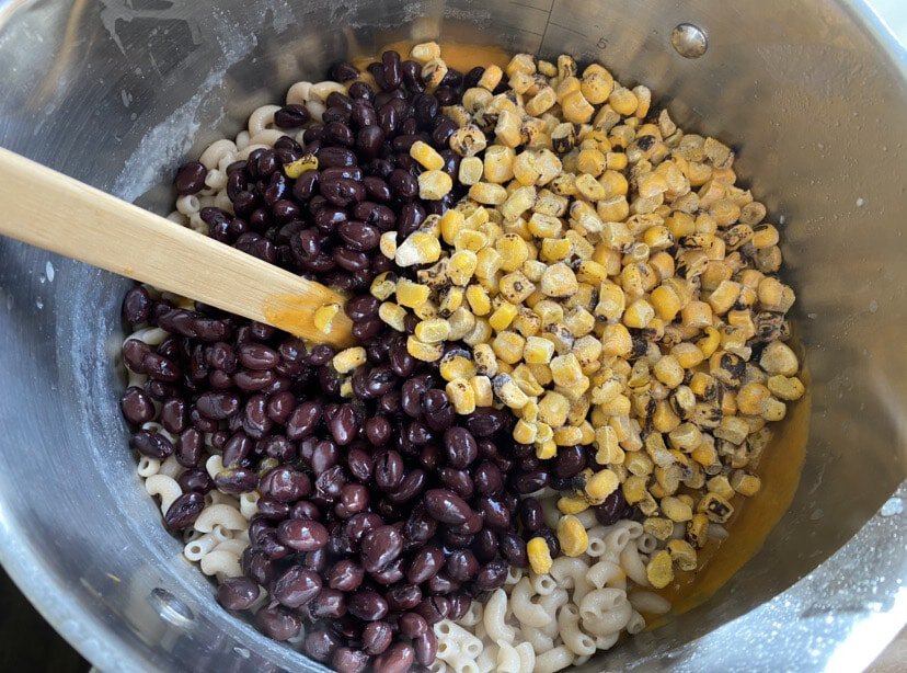 adding black beans and fire roasted corn to chili queso mac