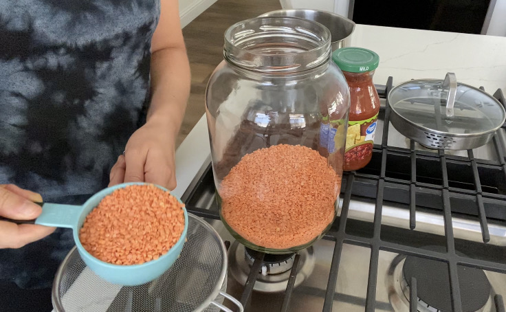 measuring 1 cup red lentils to make meatless enchiladas