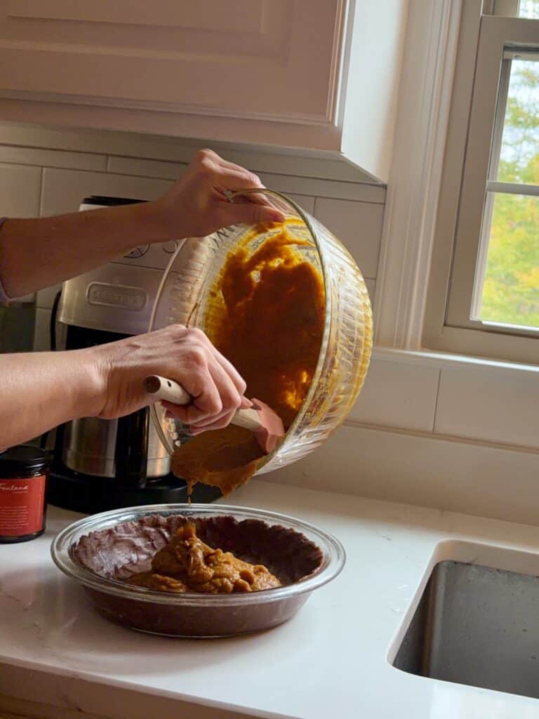 Aimee from Homemaker on a Budget whisks together pumpkin pie filling for chocolate pumpkin pie.