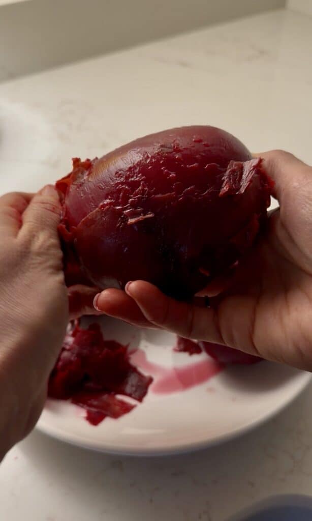 peeling beets after being boiled on the stove