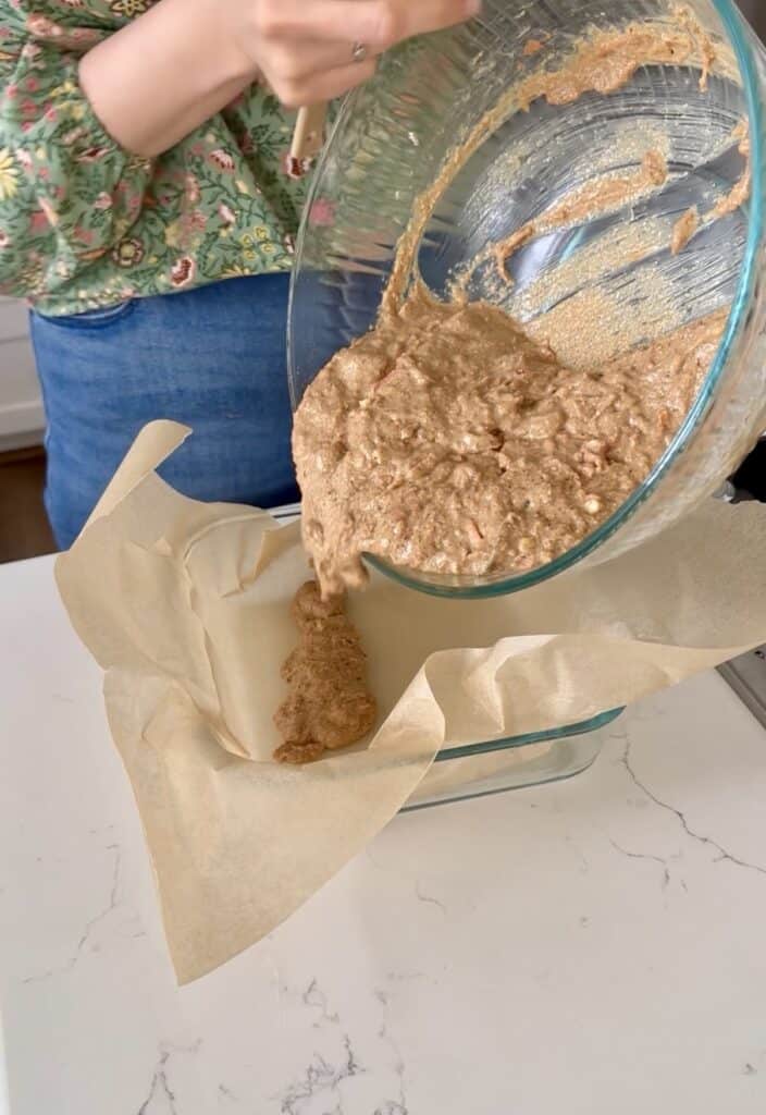 Aimee from Homemaker on a Budget pours ingredients for carrot cake snack bars recipe.