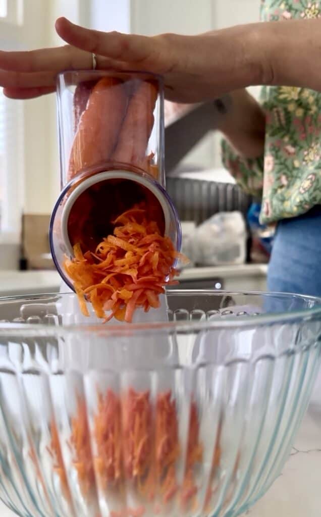 Aimee from Homemaker on a Budget shreds carrots for carrot cake snack bars recipe.