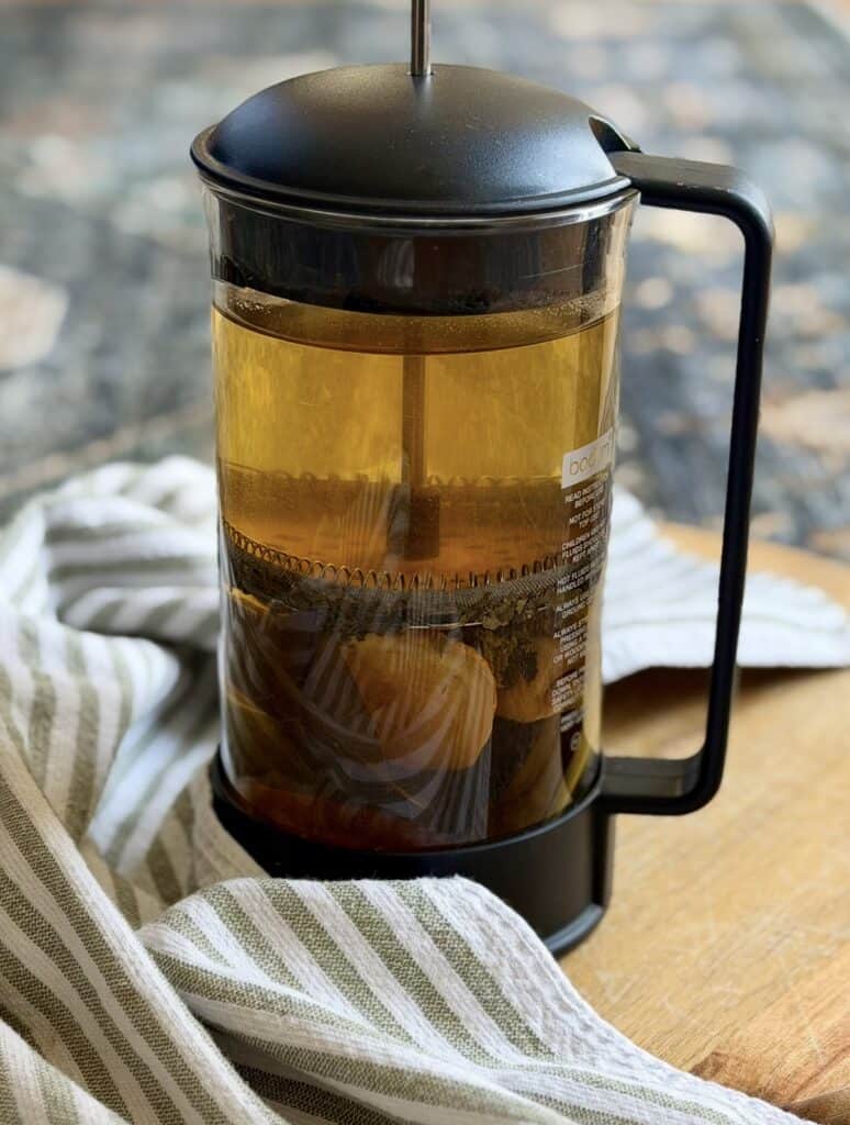 French press with dried fruit leaves