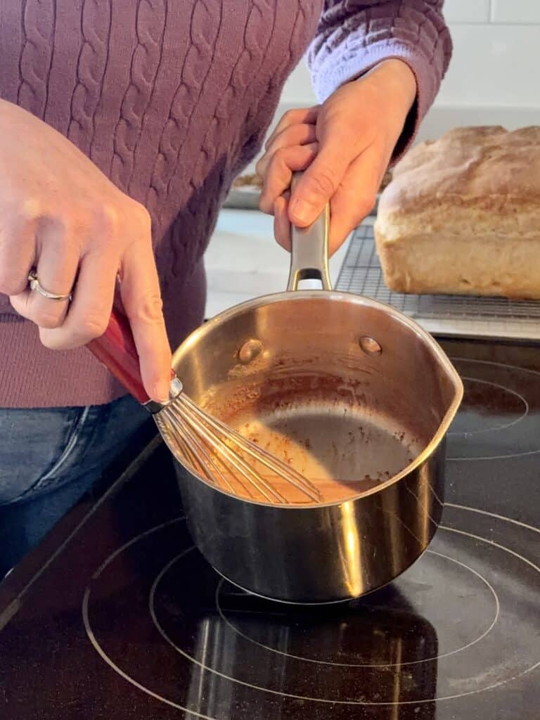 Aimee from Homemaker on a Budget whisks raw cacao powder into milk to create a delicious homemade 3-ingredient hot chocolate.