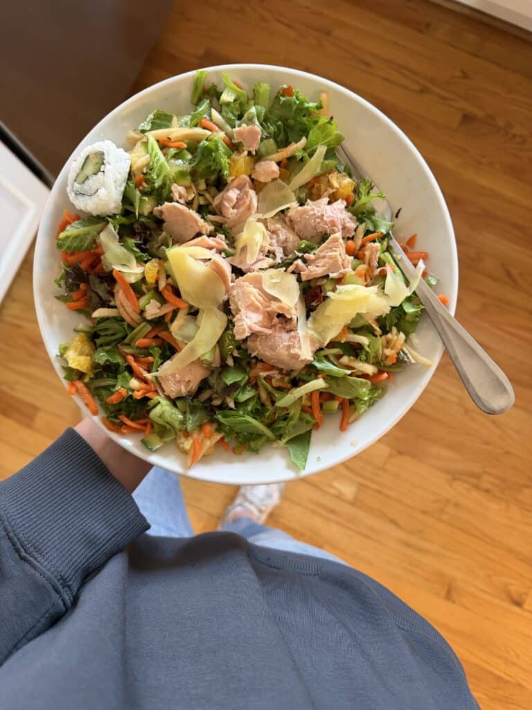 plate of salad with salmon, carrots, and oranges