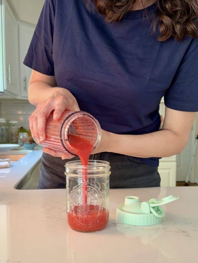 Aimee from Homemaker on a Budget pours a simple strawberry syrup from a blender.