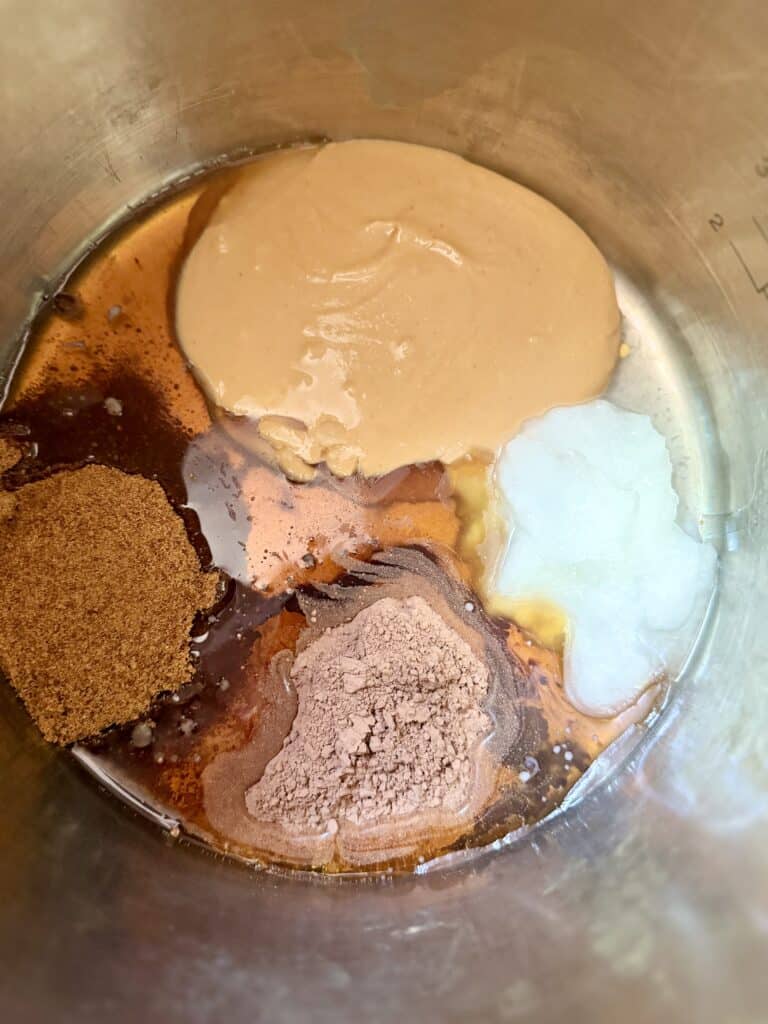 Aimee from Homemaker on a Budget combines peanut butter, cocoa, maple syrup and other  ingredients in a saucepan for peanut butter no bake cookies. 