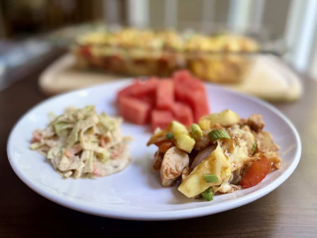 Aimee from Homemaker on a Budget enjoys Hawaiian chicken bake with a side of fresh summer fruit and slaw. 