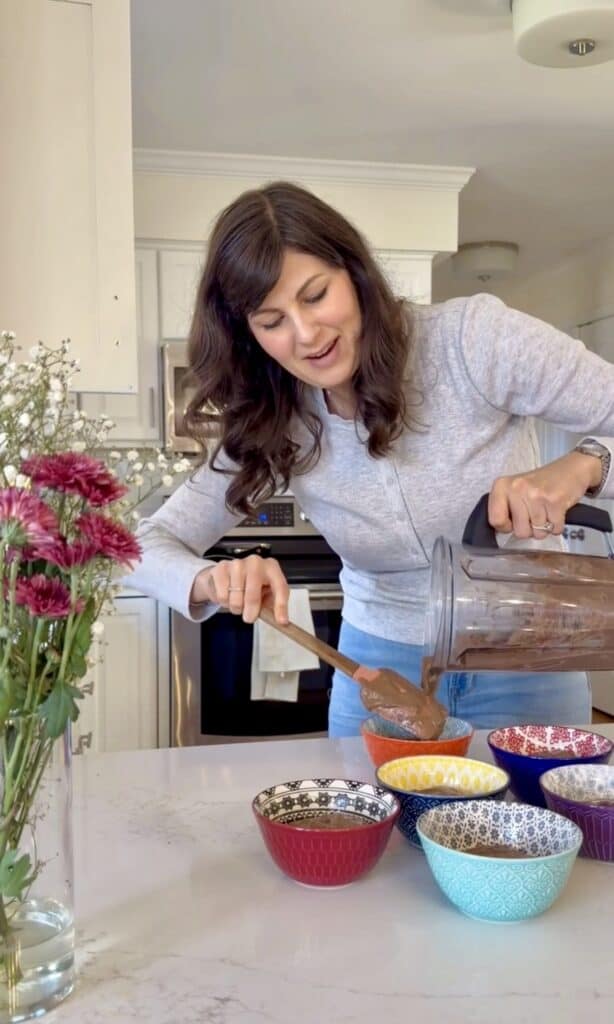 Aimee from Homemaker on a Budget pours chocolate chia seed pudding into bowls to serve as a healthy, high-protein dessert.