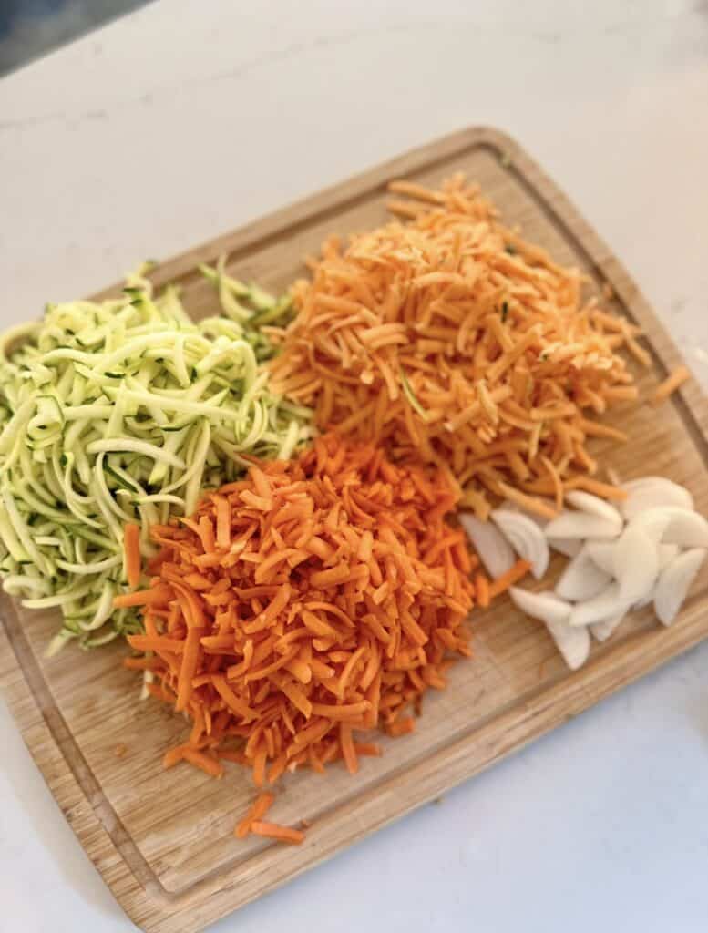 Aimee from Homemaker on a  Budget shreds colorful vegetables to add to creamy sweet potato hamburger soup. 