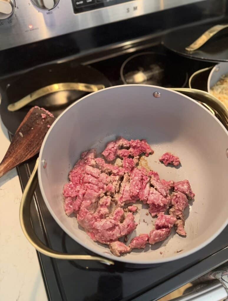 Aimee from Homemaker on a Budget browns ground beef for creamy sweet potato hamburger soup. 