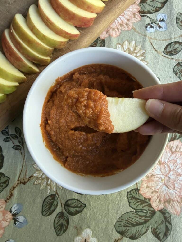 Serving with apple slices, Aimee from Homemaker on a Budget enjoys homemade pumpkin butter.